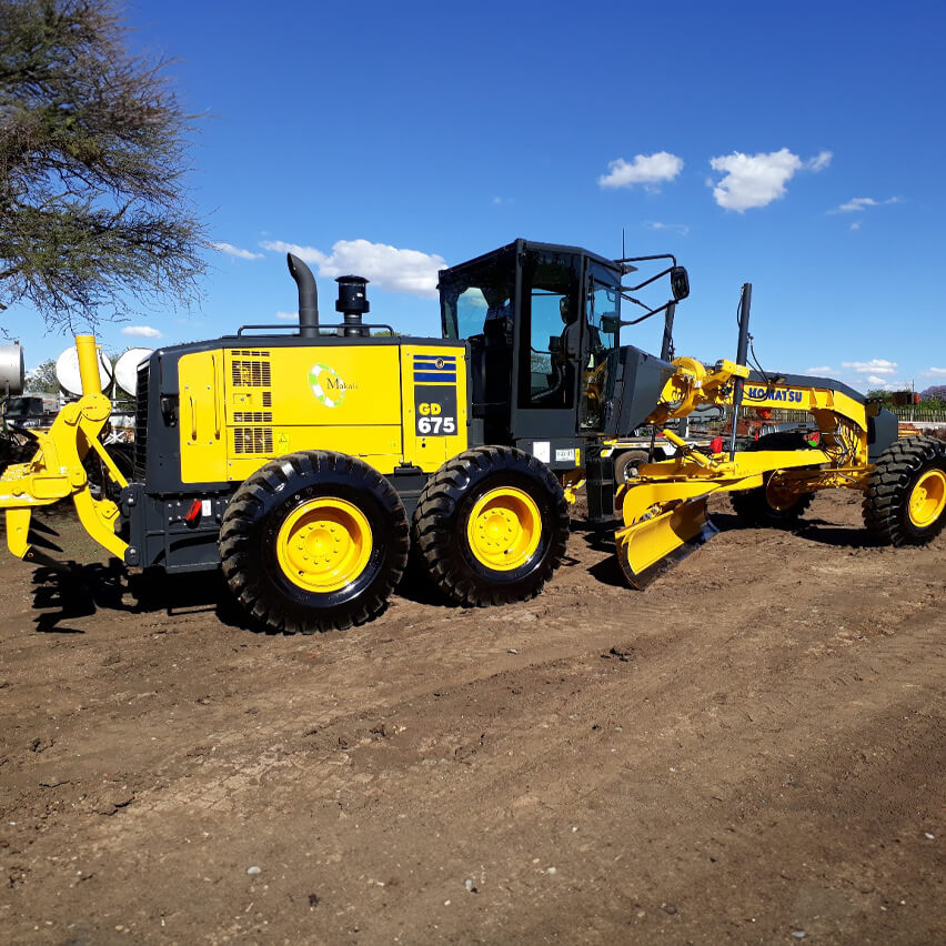 Komatsu grader, showcasing precision and efficiency in leveling surfaces for Makali Plant and Construction's infrastructure projects.